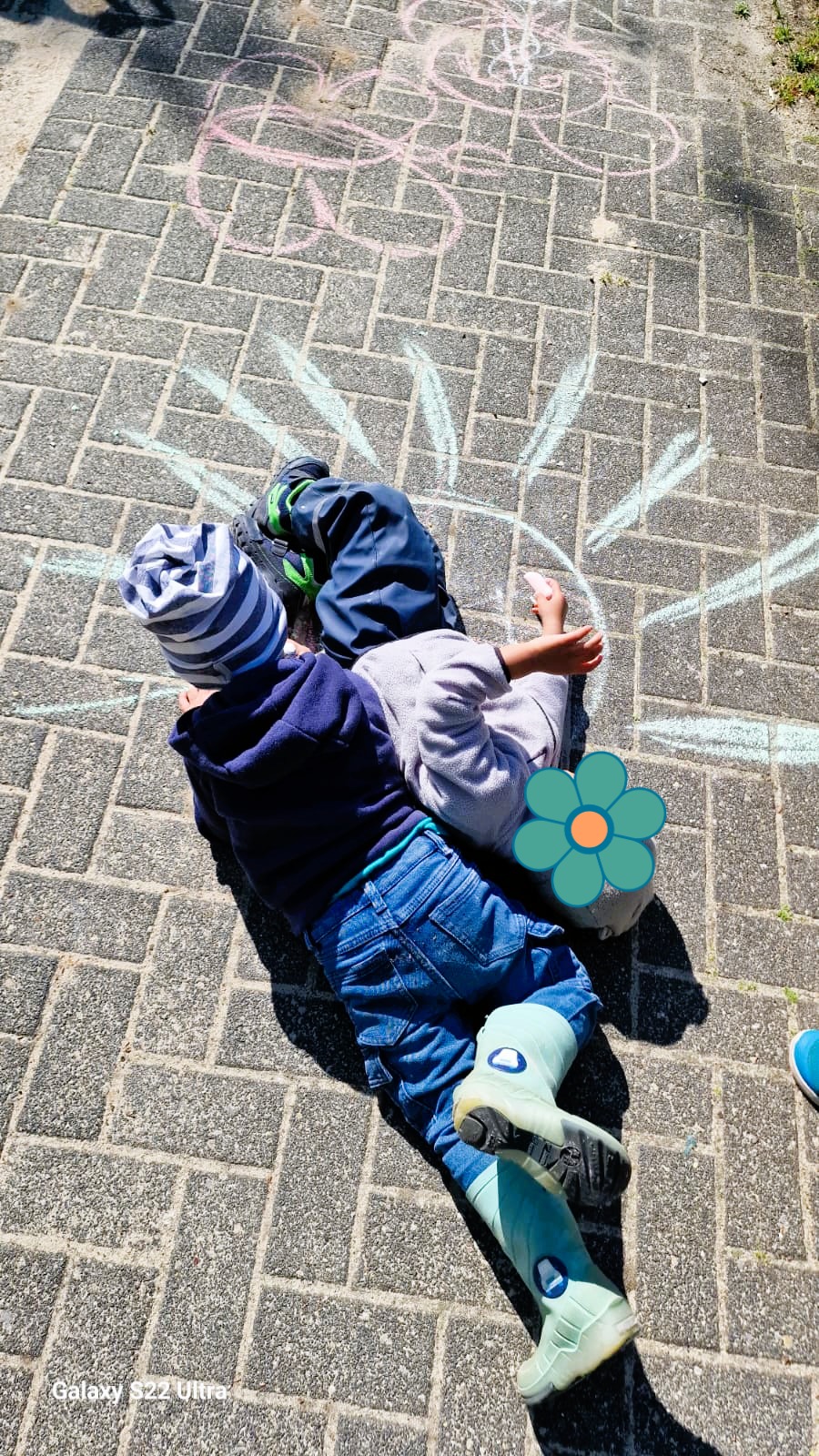Kinder beim Spielen mit Kreide im Garten der Kindertagespflege